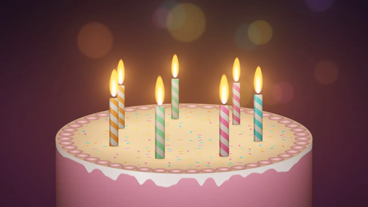 Looking down on a frosted birthday cake ringed with striped candles